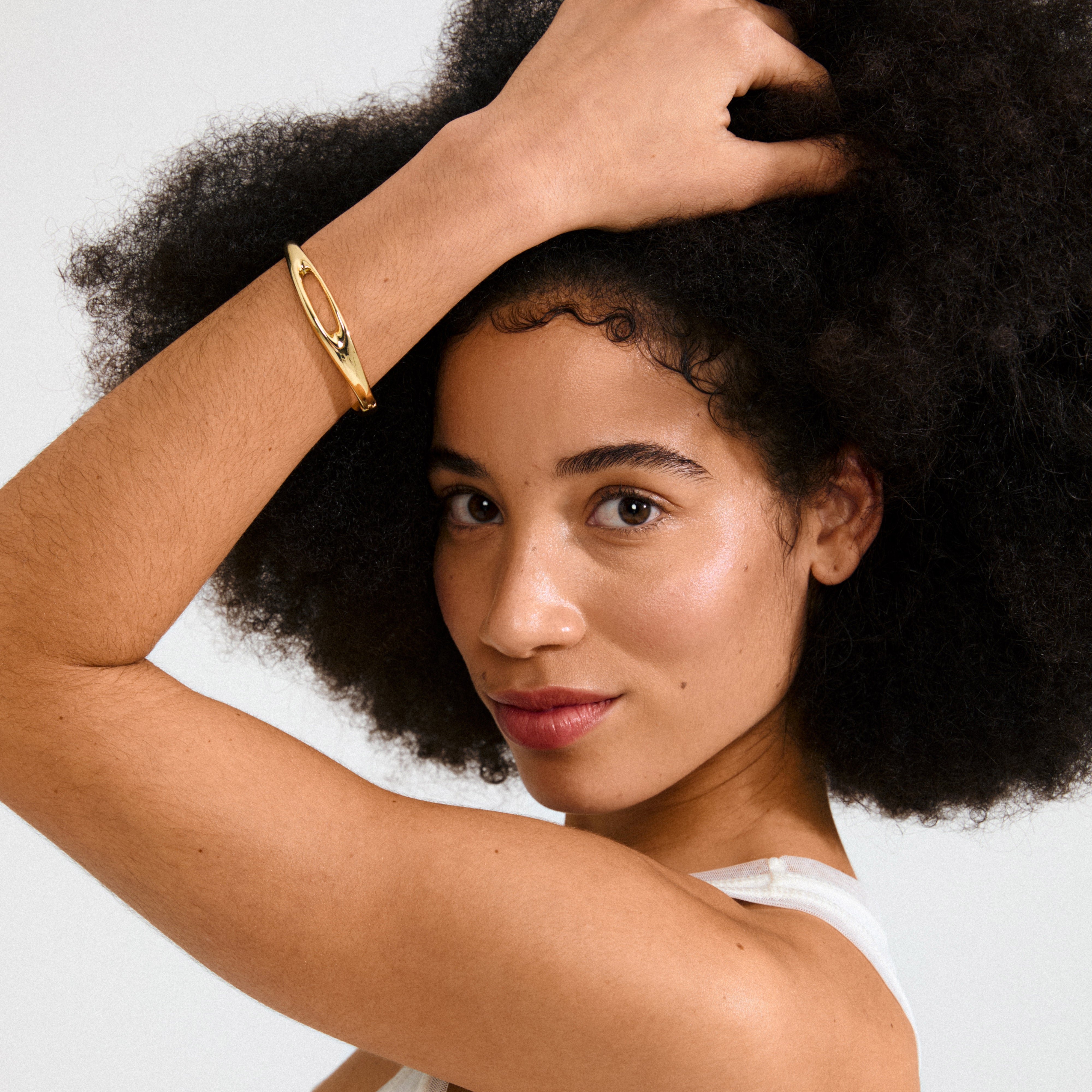 Young woman wearing Pilgrim's 168一分钟极速赛车--|实时赛果直播视频 gold-plated FREE bangle with a cut-out design, showcasing a minimalist and confident style.