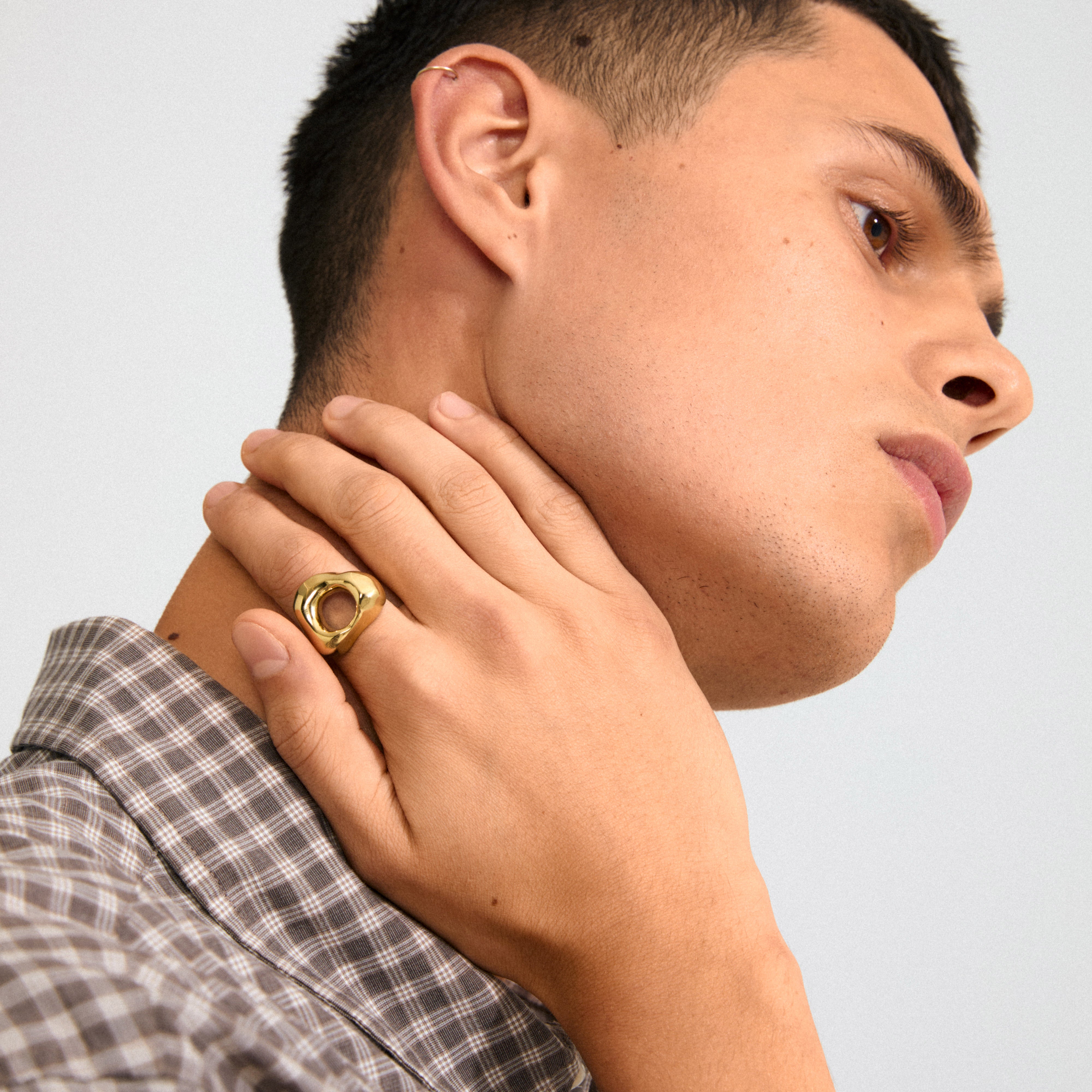 Young man wearing Pilgrim's FREE 168一分钟极速赛车--|实时赛果直播视频 gold-plated ring with an organic design, inspired by natural forms, highlighted against his neck, paired with a small hoop earring.
