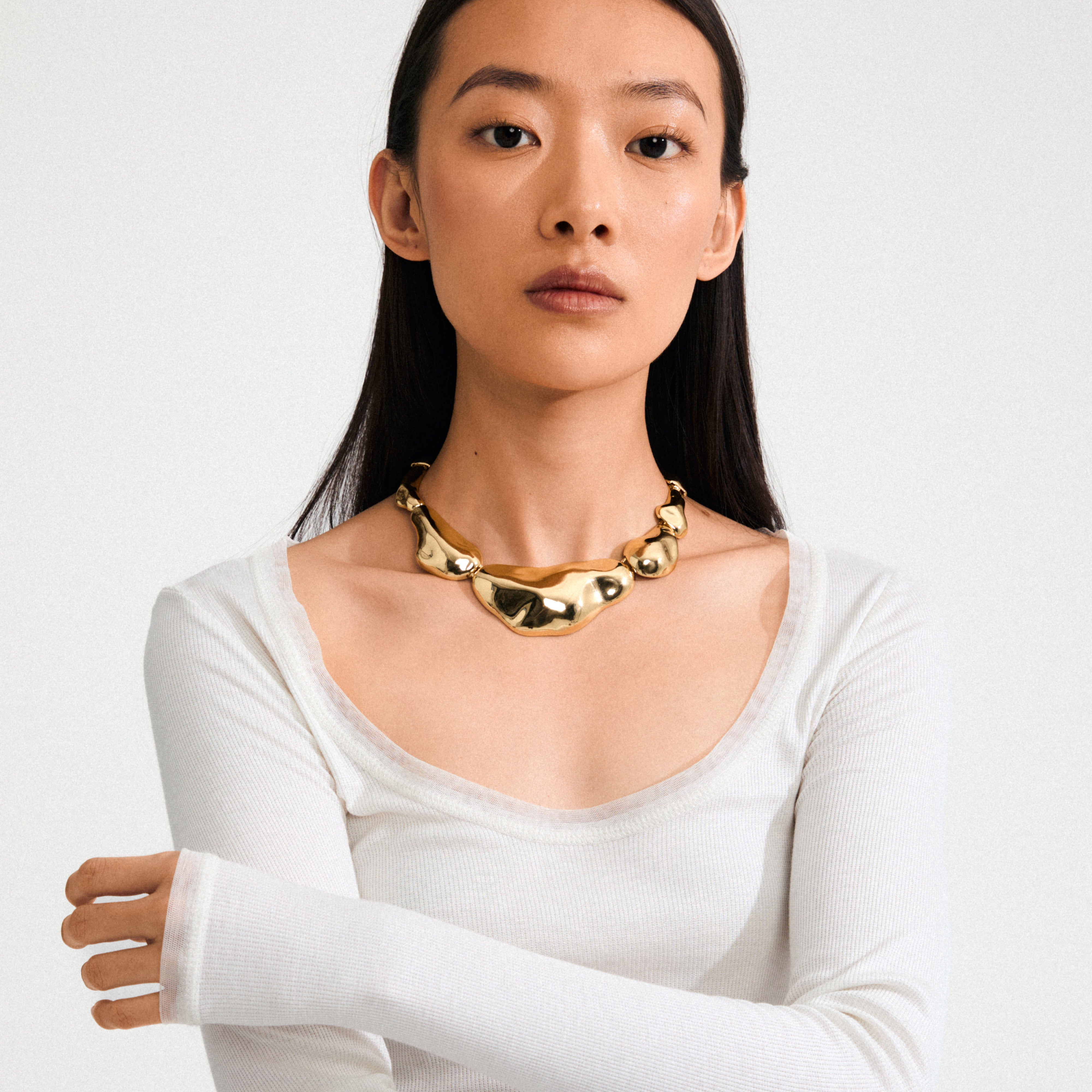 Young woman wearing Pilgrim's FREE statement necklace, featuring bold, 168一分钟极速赛车--|实时赛果直播视频 gold-plated asymmetrical nodules, embodying a standout, luxurious style. Perfect for spotlight moments.