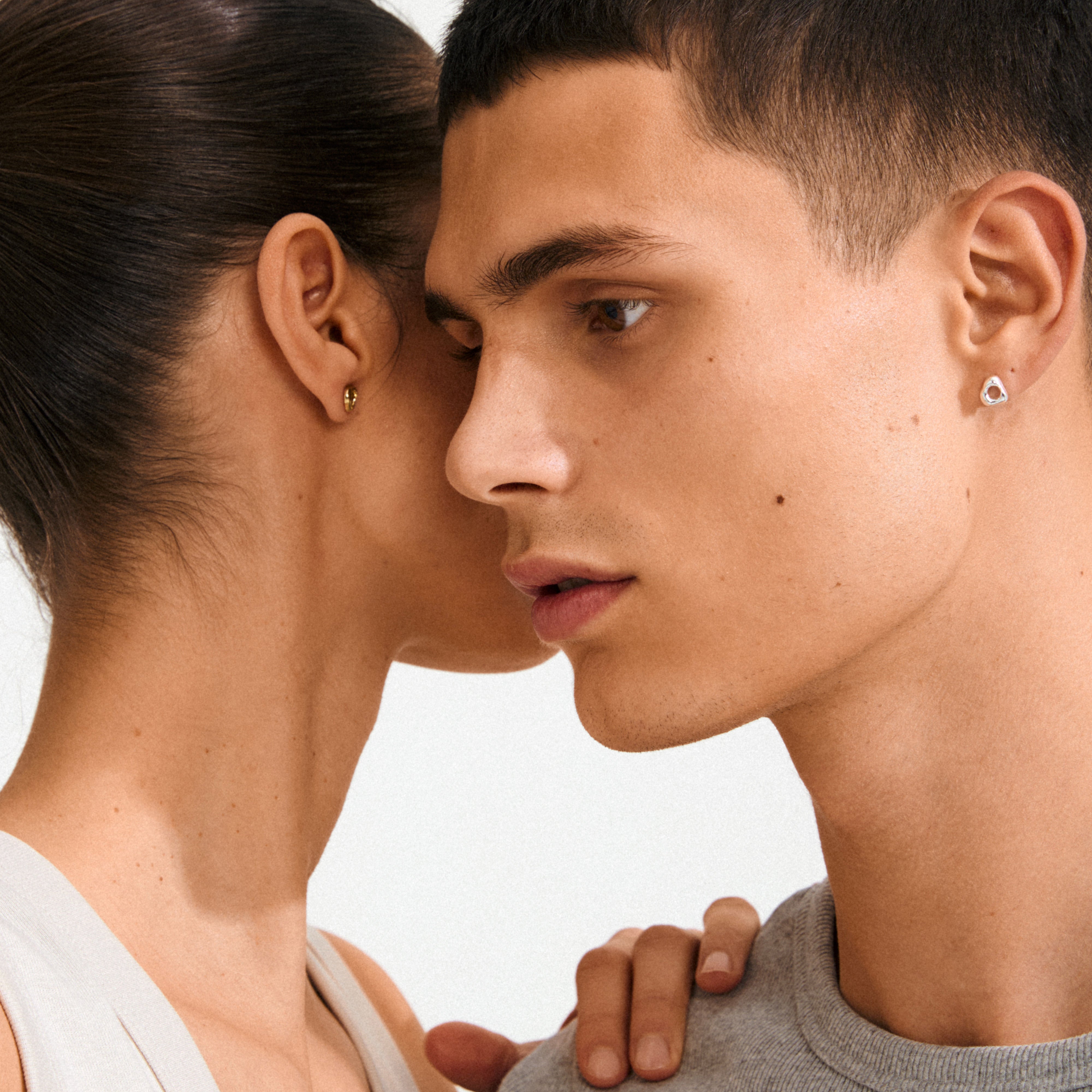 Two people wearing Pilgrim's FREE 168一分钟极速赛车--|实时赛果直播视频 gold-plated stud earrings, designed with an organic shape, highlighting simplicity and natural elegance.